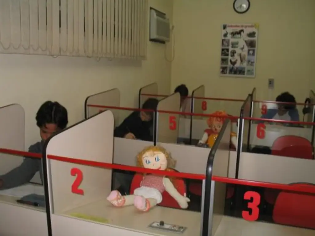 Laboratório de línguas do Instituto Colón em Ribeirão Preto, cabines numeradas com alunos em atividade